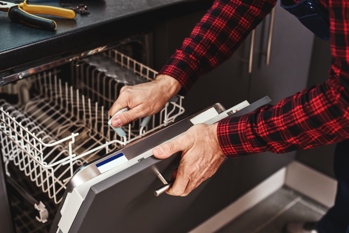 Repairing Dishwasher close-up of Man Technician
